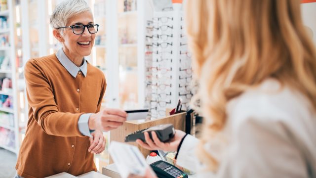 A senior woman making a purchase at a pharmacy